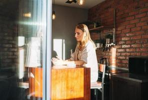 Young adult woman blonde long hair with glass of water on morning kitchen at the home, healthy lifestyle photo