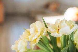 hermoso ramo de tulipanes amarillos en un jarrón en el alféizar de la ventana en casa, fondo natural foto