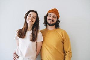 Portrait of happy couple young family laughing against gray wall photo