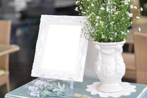 Blank  frame on the table ans flower vase photo