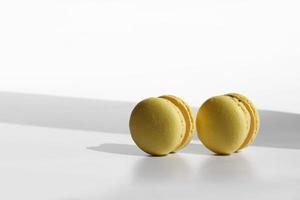 Abstract pattern with yellow macaroons or macarons on white background with shadows. Seamless pattern. Delicious healthy french dessert. Creative minimal modern concept. photo