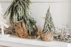 Christmas composition. Two Christmas fir trees with burlap and artificial snow, on wooden white rustic background. Merry Christmas, New Year, Happy Holidays, Template. Greeting card. 2023 photo