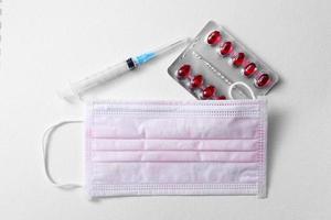 Medical masks, pills, syringe, symbol covid-19, coronavirus, medical drugs on a white background. Hygiene and Healthcare concept.Copy space photo