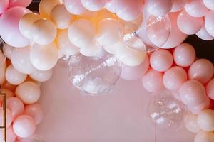 festive arch with pink balloons. Balloons photo wall birthday decoration. Balloons on pastel pink background. colourful balloons.