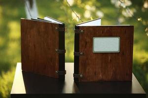 two wooden photo books on the table in the nature. place for the inscription.side view