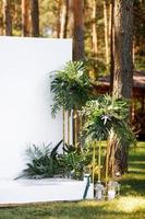 Wedding decorations in luxury ceremony. Arch for wedding ceremony a is decorated with flowers and greens, greenery. wedding decor outdoors in the forest on summer sunny day. photo