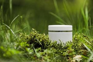 Cosmetics, skin care, beauty, body treatment concept. White cosmetic jar, tube, bottle on green moss background. Top view. Mock-up. Vegan eco friendly. Biophilic design photo