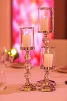 candles on a glass candlestick. Burning candle in a round glass candlestick with decorative seashells photo