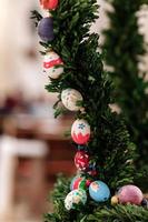 Easter background - colorful ester eggs hanging on fir tree. Easter eggs on Christmas tree photo