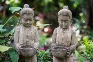 Stone sculpture of kids holding bowl photo