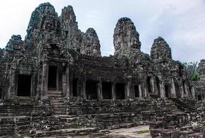 Prasat Bayon with smiling stone faces is the central temple of Angkor Thom Complex, Siem Reap, Cambodia. Ancient Khmer architecture and famous Cambodian landmark, World Heritage. photo