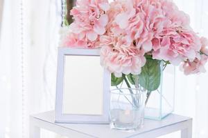Blank  frame on the table and flower decoration photo
