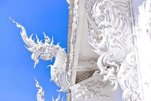 The white architecture in Wat Rong Khun, the famous white temple of Thailand photo