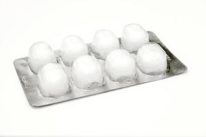 bolas de algodón médicas sumergidas en alcohol en un paquete de plástico aislado sobre fondo blanco. foto