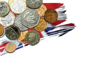 Top view and crop of British currency coins put on The UK flag in paint brush style and isolate on white background. photo