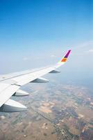 Wing of an airplane flying in the sky over the town photo