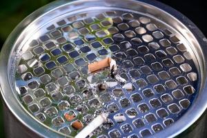 cigarrillos en cenicero al aire libre, primer plano foto