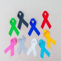 día mundial contra el cáncer, 4 de febrero. cintas de colores para apoyar a las personas que viven y están enfermas. cuidado de la salud, lucha, día médico y nacional de supervivencia del cáncer, concepto del día de concientización sobre el autismo foto