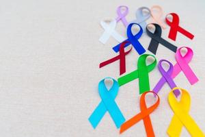 día mundial contra el cáncer, 4 de febrero. cintas de colores para apoyar a las personas que viven y están enfermas. cuidado de la salud, lucha, día médico y nacional de supervivencia del cáncer, concepto del día de concientización sobre el autismo foto