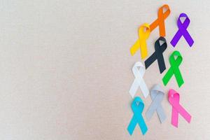 día mundial contra el cáncer, 4 de febrero. cintas de colores para apoyar a las personas que viven y están enfermas. cuidado de la salud, lucha, día médico y nacional de supervivencia del cáncer, concepto del día de concientización sobre el autismo foto