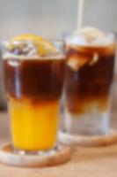 Glass of americano mixed with orange juice blur background photo