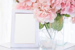 Blank  frame on the table and flower decoration photo