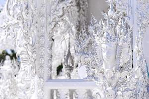 The white architecture in Wat Rong Khun, the famous white temple of Thailand photo