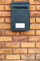 Wood post box on brick wall photo