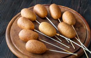 Corn dogs on wooden board photo