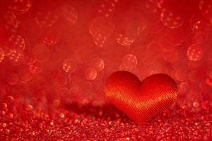 corazón rojo sobre fondo bokeh rojo borroso. símbolo de amor. día de San Valentín foto