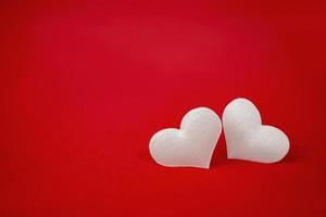 dos corazones blancos sobre un fondo rojo. vacaciones del día de san valentín. símbolo de amor.