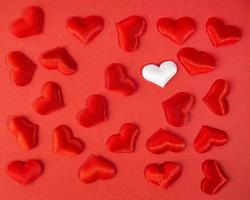 corazones rojos y blancos sobre un fondo rojo. vacaciones del día de san valentín. símbolo de amor.