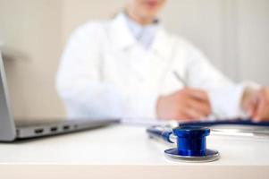 HEalthcare concept.Closeup of stethoscope on doctor's table with doctor working in the background. Banner with place for text photo