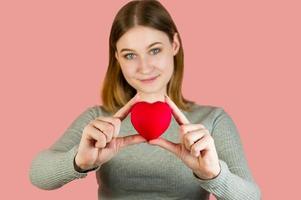 Closeup studio portrait of young female holding heart.ST valentine's day concept.Selective focus photo