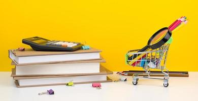 Education, Back to School. Shopping cart with supplies near pile of books. photo