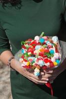 Sweet bridal bouquet. Multicolored jelly beans in unrecognizable woman hands photo