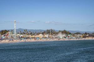 Distant view of amusement park rides and Santa Cruz Beach in front of ocean photo