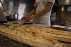 Close-up of fresh Turkish cheese pide on counter at restaurant