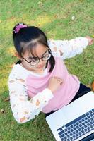 Cute girl is happy with notebook on grass photo