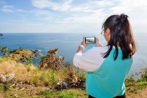 mujer tomando fotografía con smartphone foto