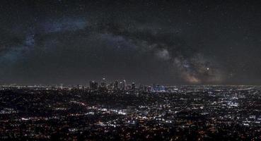 Aerial view of modern illuminated cityscape with beautiful stars shining in sky photo