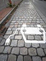 Electric car charging sign painted on paving stones on a city street. photo