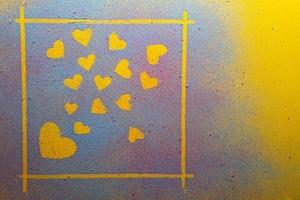 Valentine's Day. Set of hearts a symbol of love in a frame, made of multicolored bright powder, on a yellow background. Copy space. photo