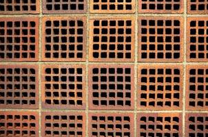 Red brick wall with square holes. Copy space. Abstract background. photo