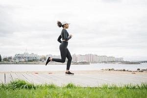 A female runner is running fitness training in a tight-fitting tracksuit. photo