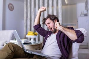 Tired man yawning after long working day . Early morning working. Sleepy tired freelancer is yawning at his home photo