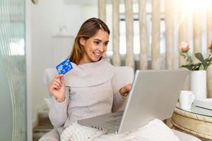 Young beautiful woman happy for finding shopping items for sale online. Beautiful girl using laptop computer for online shopping at home photo