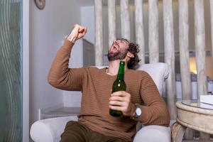 vamos, equipo, vamos, el verdadero aficionado nunca se pierde un partido. concepto de deportes, felicidad y personas - hombre sonriente viendo deportes en la televisión y apoyando al equipo en casa. vamos equipo vamos foto