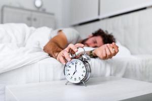 Sleep longer. Health care concept. Stages of sleep. Man awake unhappy with alarm ringing. Although you sleep you may wake up feeling like did not sleep at all. photo