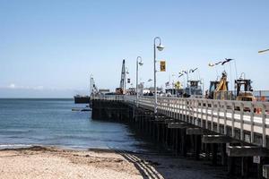 People and vehicles on Santa Cruz Municipal Wharf by sea during summer photo